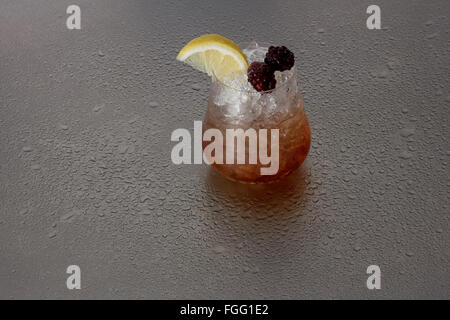 Bramble cocktail on wet metal surface Stock Photo