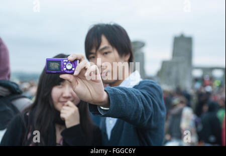 Chinese tourists taking a selfie photo Stonehenge,Summer Solstice sunrise June,Wiltshire,England, Stock Photo