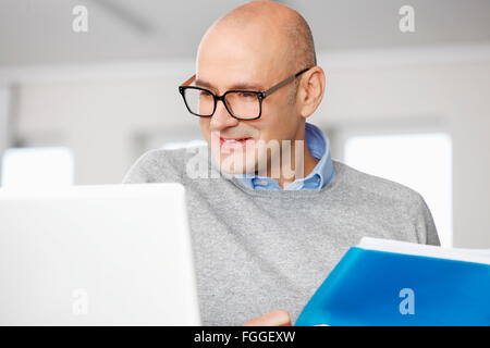 Portrait of sales man analyzing data while sitting in front of laptop. Stock Photo