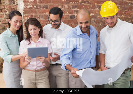 Architect colleagues working on blueprints and digital tablet Stock Photo