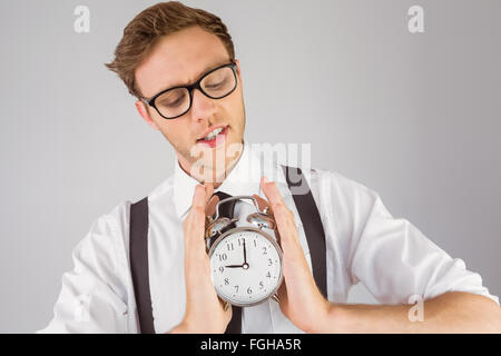 Geeky businessman holding alarm clock Stock Photo