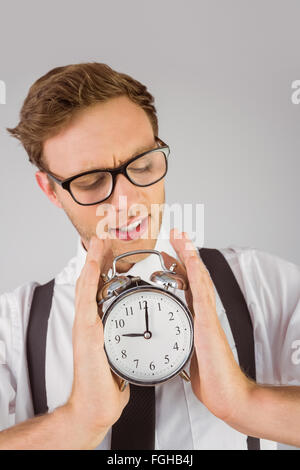 Geeky businessman holding alarm clock Stock Photo