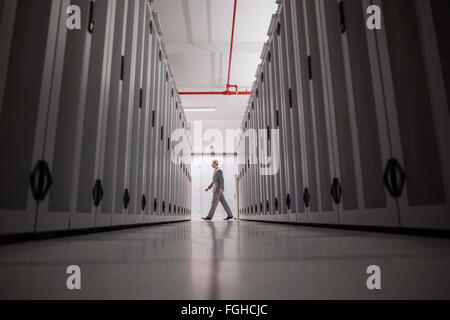 Technician walking in server hallway Stock Photo
