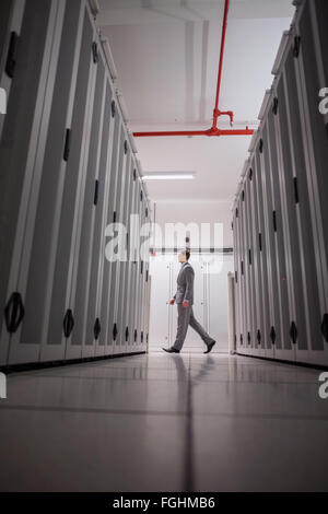 Technician walking in server hallway Stock Photo