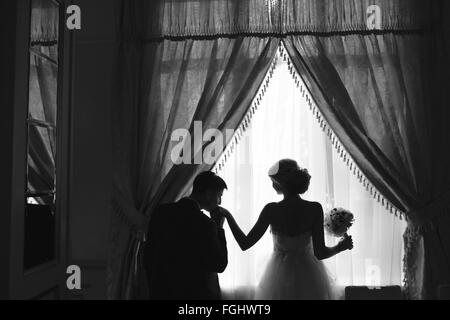 bride and groom standing in front of window Stock Photo