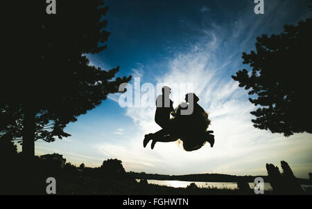 groom and bride jumping against the beautiful sky Stock Photo