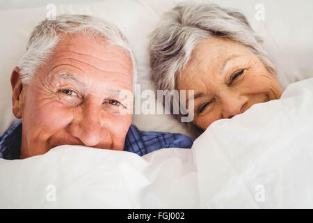 Happy senior couple smiling in bed Stock Photo