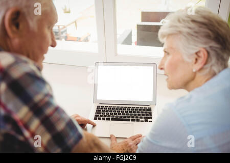 Senior couple talking while using laptop Stock Photo