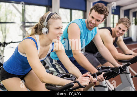 Fit group of people using exercise bike together Stock Photo