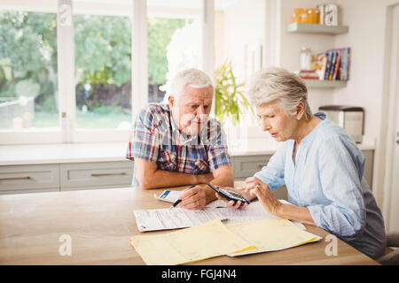 Worried senior couple checking their bills Stock Photo