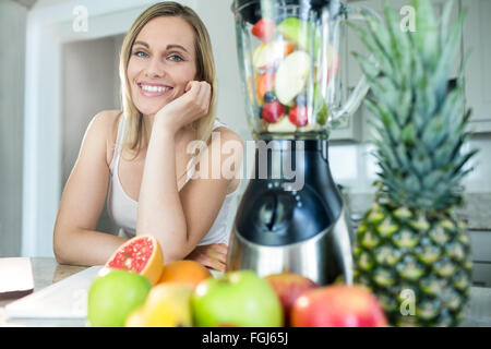 Pretty blonde woman happy to prepare a smoothie Stock Photo