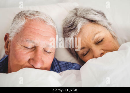 Senior couple sleeping on bed Stock Photo