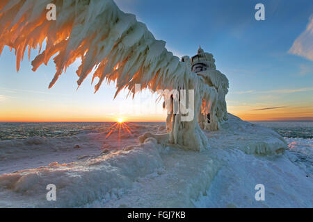 A Lake Michigan winter sunset illuminates the ices that encapsulates the St. Joseph northern pier light Stock Photo