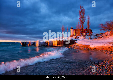 Point Betsie Lighthouse in winter on the shores of Lake Michigan. Sunset shines on the winter scene in northern Michigan Stock Photo