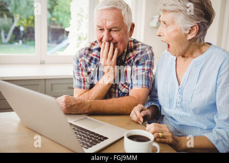 Surprised senior couple using laptop Stock Photo