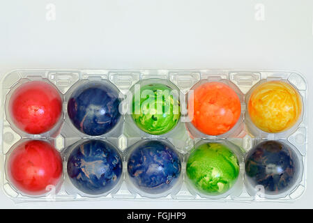 colorful Easter eggs in a plastic box, close up on white background, horizontal, Stock Photo