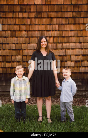 Mom with two kids, both boys, in a lifestyle portrait outdoors. Stock Photo