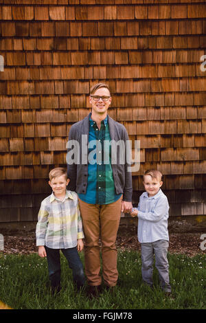 Dad with two kids, both boys, in a lifestyle portrait outdoors. Stock Photo
