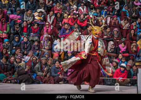 Monk is dancing in arena and audience in background enjoying performance Stock Photo