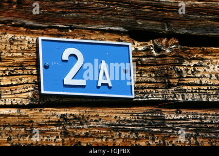 A blue number plate showing 2 A fixed on an old farm house Stock Photo