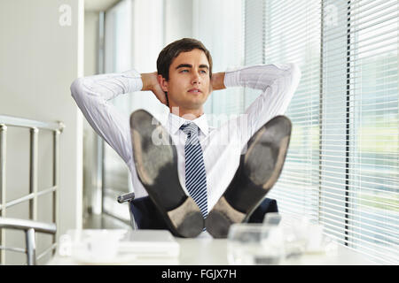 Relaxed businessman sitting in office Stock Photo