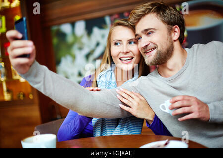 Amorous young couple making selfie in cafe Stock Photo