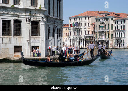 A group of gondoliers and tourists boating on the Grand Canal in Venice Stock Photo