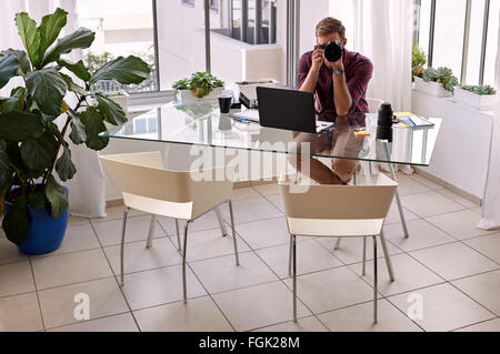 Professional photographer sitting in his home studio Stock Photo