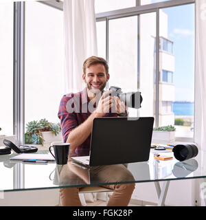 Square image of photographer holding his camera Stock Photo