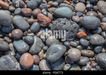 Santorini - The detail of pemza from Black beach in the wave . Stock Photo