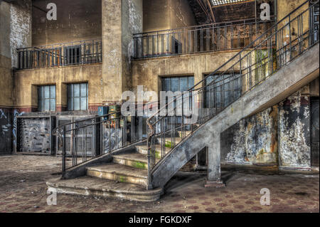 Imposing staircase inside the hall of an abandoned power plant Stock Photo