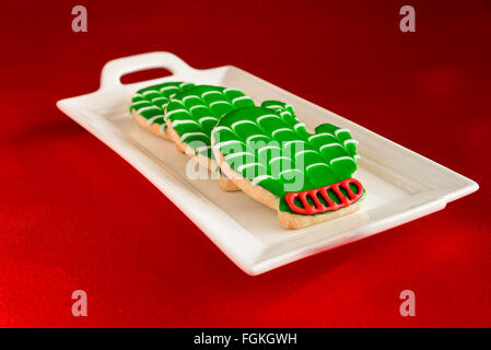 Holiday mitten cookies on a white platter and red background Stock Photo
