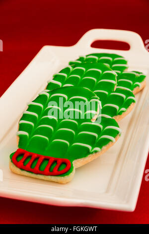 Holiday mitten cookies on a white platter and red background Stock Photo