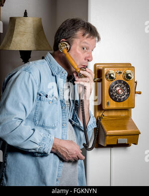 Surprised expression by man on old phone Stock Photo