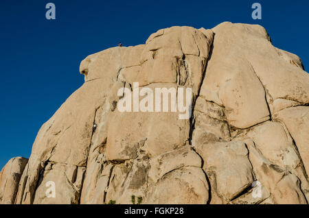 Rock climbers on large boulder during a sunny winter day Stock Photo