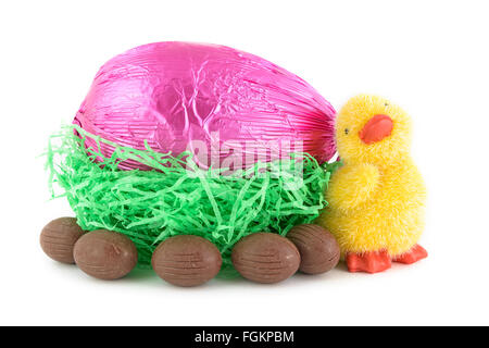 toy chick and chocolate easter eggs in nest isolated on white background Stock Photo