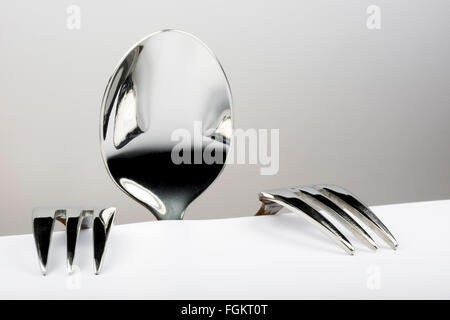 Spoon and two forks formed into conceptual figure Stock Photo