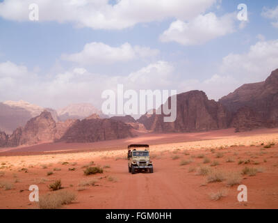 A jeep crossing the red sands of the Wadi Rum desert Stock Photo