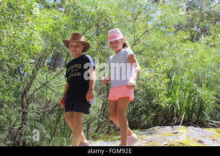 Eight year old boy and girl smiling as they hike in the countryside Stock Photo