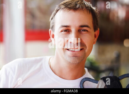 Close-up portrait of a smiling young man. Male looks into the camera. Selective focus on the model's face. Stock Photo