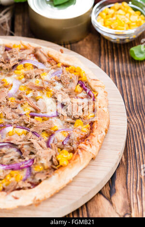 Fresh made Tuna Pizza (close-up shot) on rustic wooden background Stock Photo