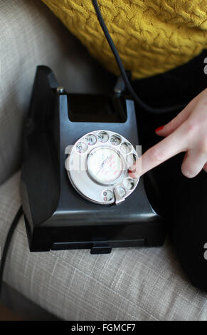 Close up of someone's finger dialing a number on a vintage telpehone Stock Photo