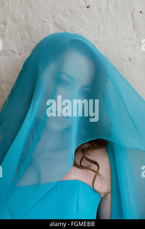 Beautiful Mature woman covered with a blue chiffon Stock Photo