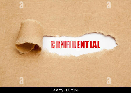 The word Confidential appearing behind torn brown paper. Stock Photo