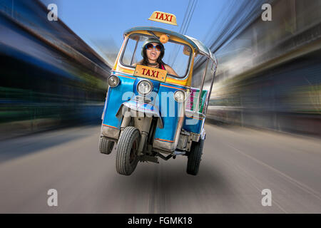 traditional tricycle taxi rides on the streets of Bangkok Stock Photo