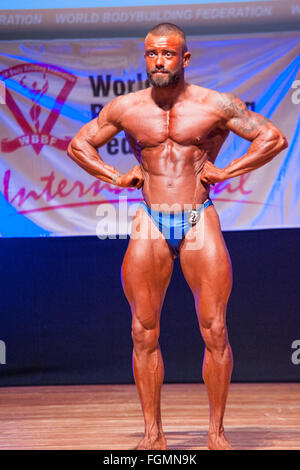 MAASTRICHT, THE NETHERLANDS - OCTOBER 25, 2015: Male bodybuilder Dennis Theys flexes his muscles and shows his best front pose Stock Photo