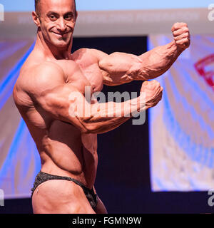 MAASTRICHT, THE NETHERLANDS - OCTOBER 25, 2015: Male bodybuilders flex their muscles and shows their best front pose on stage Stock Photo