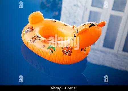 floating ring on blue water swimming pool with waves reflecting in the summer sun. Stock Photo