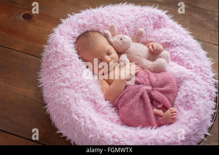 Newborn Baby Girl Sleeping with a Stuffed Animal Rabbit Stock Photo