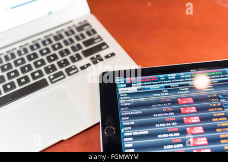 Stock graph on tablet with a notebook on a wood tablet Stock Photo